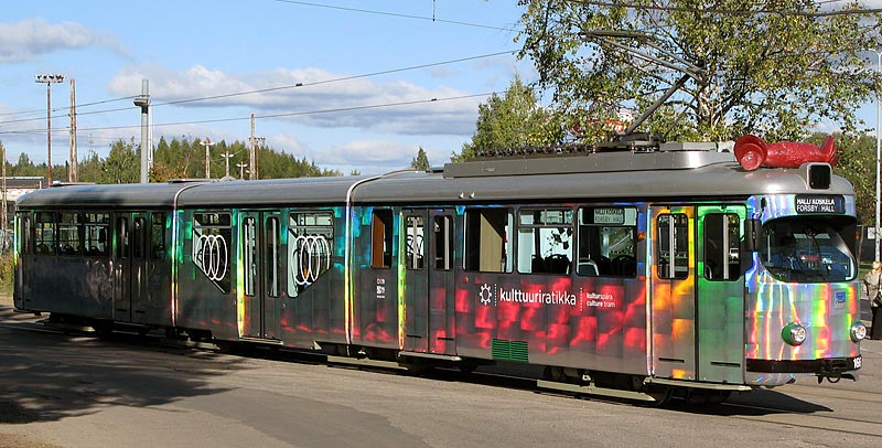 HKL 166 Koskelassa 29.9.2010 menossa linjalle. Aurinko saa vaunun "sateenkaaren" vreihin.